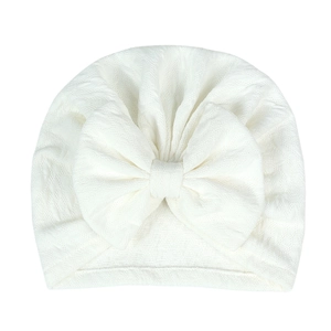 Detailed view of white newborn baby hat with large soft bow and elastic knit texture