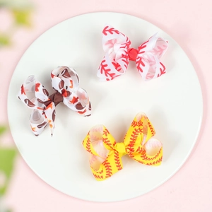 Three 3-inch baseball print bow hair clips in a white tray with textured grosgrain ribbon