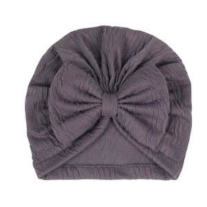 Close-up of deep purple ripple texture newborn baby turban hat with a large bow