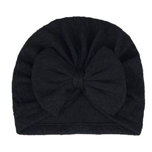 Detail of black newborn turban hat featuring a large bow and waffle textured knit fabric