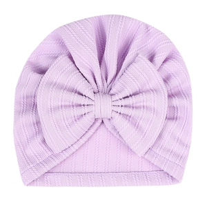 Soft lavender newborn ribbed knit hat featuring a large elastic bow on a white background