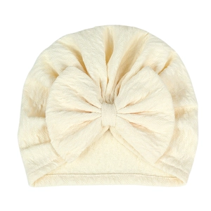 Detail showing the textured honeycomb knit fabric and large bow on this baby turban hat