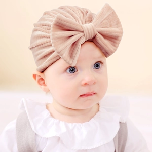Detailed close-up of baby turban hat featuring a large velvet bow and ribbed texture