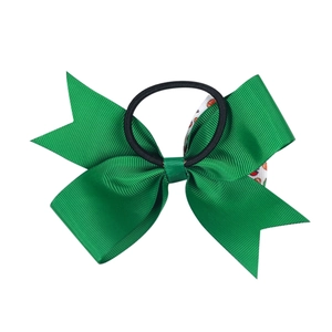 Dettaglio del fiocco per capelli in gros-grain verde con elastico nero e nastri stampati