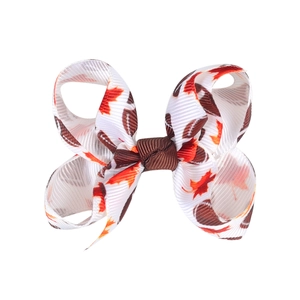 Detailed close-up of 3-inch grosgrain hair bow featuring autumn maple leaf print patterns