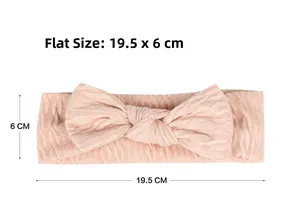 Détail de la taille à plat du bandeau bébé en tricot rose avec nœud, longueur 19,5 cm