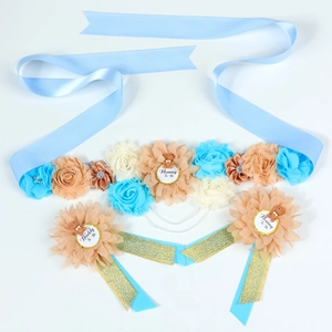 Detail of baby shower sash with blue fabric flowers and Mommy To Be teddy bear badge