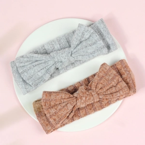 Close-up of soft ribbed knit baby headbands in grey and brick red colors with a bunny knot