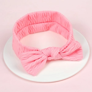 Bandeau élastique rose pour bébé avec un grand nœud et une texture côtelée