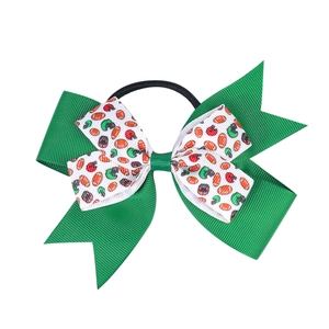 Dettaglio di un fiocco per capelli a tema football con nastri verdi per le cheerleaders