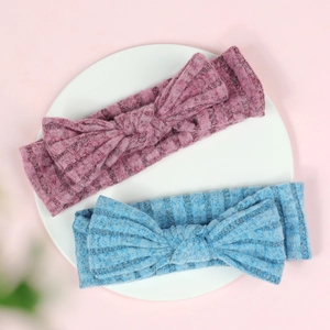 Detail of pink and blue soft ribbed knit baby headbands with large bow accents