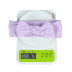 Light purple knitted baby headband weighing 18.3g with a large knot bow and diamond texture