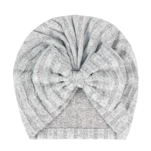 Détail du bonnet de naissance gris avec grand nœud décoratif et texture rayée