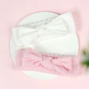 Detail of soft ribbed knit baby headbands with bow knot in white and pink colors