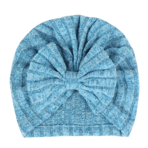 Gros plan détaillé d'un bonnet pour bébé en tricot bleu avec un grand nœud doux