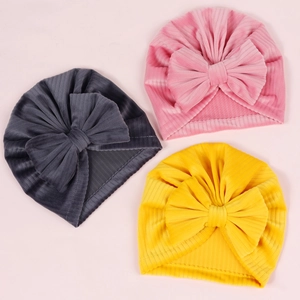Detailed view of three ribbed baby turban hats in grey, pink, and yellow with large bows