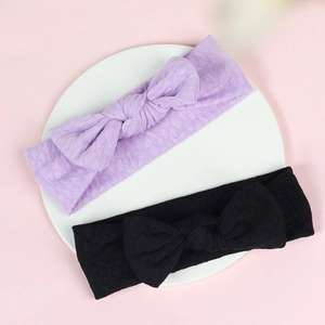 Detail of purple and black knitted baby headbands with textured bow knot and soft fabric