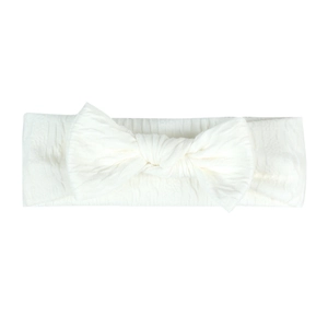 Détail d'un bandeau pour bébé blanc crème en tissu côtelé avec un nœud papillon souple