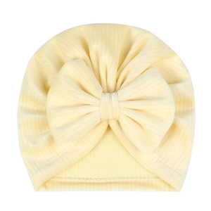 Detail of baby turban hat in cream yellow ribbed knit fabric with a soft bow