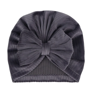 Detailed view of dark grey velvet baby turban hat featuring a large bow and ribbed texture