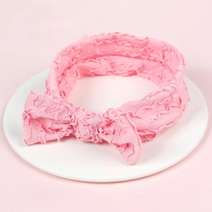 Soft pink ruffled baby headband with large bow made of skin-friendly elastic fabric