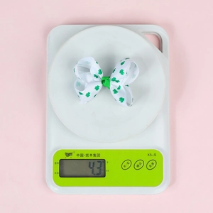 Détail d'un nœud blanc de 3 pouces à trèfles verts affichant un poids de 4,3 grammes
