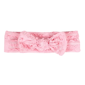 Close-up of pink elastic baby headband featuring a large ruched bow and soft fabric texture