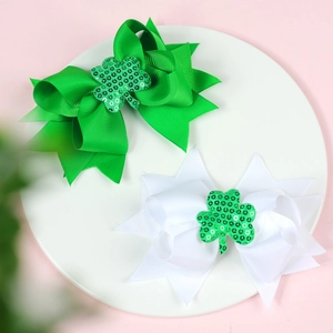 Détail de pinces à cheveux Saint-Patrick avec trèfles à paillettes vertes sur nœud côtelé