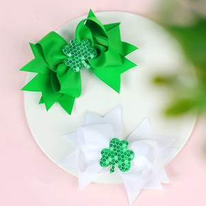 Détail de pinces à cheveux à nœuds vert et blanc pour la Saint-Patrick avec trèfles brillants