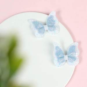 Detailed close-up of double-layered blue glitter butterfly hair clips for girls
