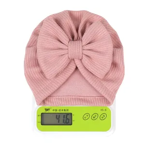 Detailed view of pink newborn turban hat with bow weighing approximately 41.6 grams