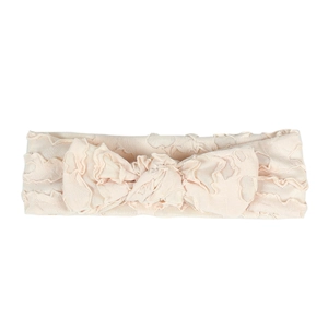 Detailed macro view of soft beige baby headband with pleated texture and large bow detail
