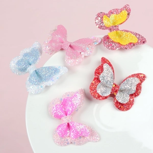 Set of five colorful glitter butterfly hair clips displayed on a white round plate