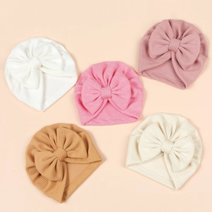 Set of five ribbed knit baby hats with large bows in soft pastel and earthy colors
