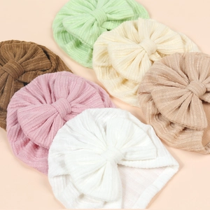 Detail of baby turban hats with large bows in six solid colors and ribbed knit texture