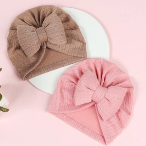 Detailed texture of pink and brown infant turbans with large bows and knit fabric