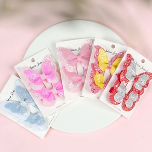 Five pairs of glitter butterfly hair clips for girls displayed on white cards