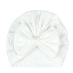 Detail of white rib-knit baby turban hat with a large soft bow for infants