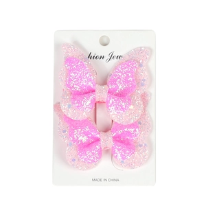 Close-up of dual-layer pink glitter butterfly hair clips set on a display card