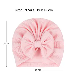 Pink infant turban hat with large bow detail and soft pleated fabric texture measurements