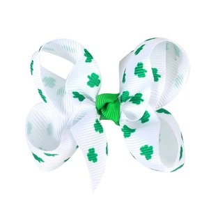 Détail d'une pince à cheveux en ruban gros-grain blanc avec motif trèfles de la Saint-Patrick