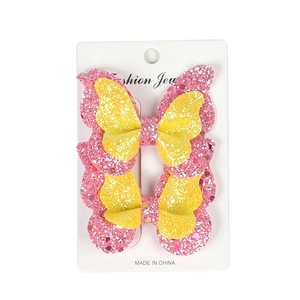 Close-up of double-layered pink and yellow sequined butterfly hair clips on a white card