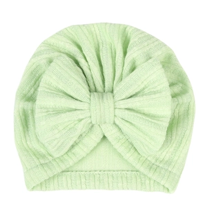 Detailed macro view of mint green ribbed knit fabric and large bow on the baby turban hat