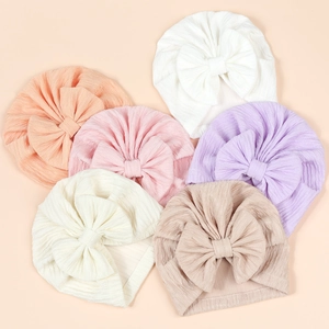 Detail view of baby bow turban hats in six soft colors with ribbed texture and large bows