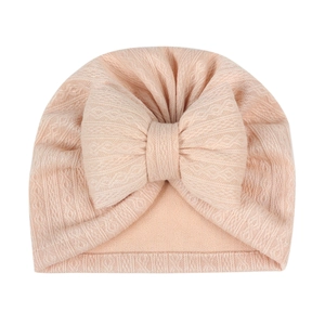 Detailed view of pink ribbed infant turban hat with a large decorative cotton bow