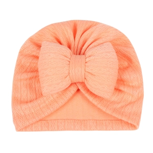 Detail of baby turban hat featuring a large cotton bow and soft ribbed knit texture