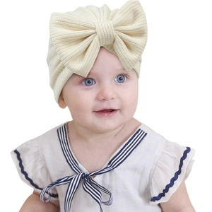 Infant striped knit turban hat featuring a large bow detail in beige for baby girls