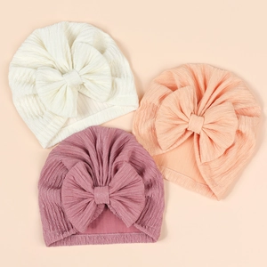 Detailed view of three newborn turban hats with soft ribbed texture and large bows