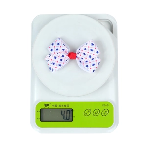 Close-up showing the weight of a star-patterned bow hair clip on a digital scale