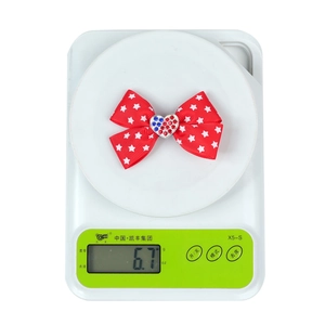 Star pattern hair bow with heart rhinestones weighing approximately 6.7g on a scale